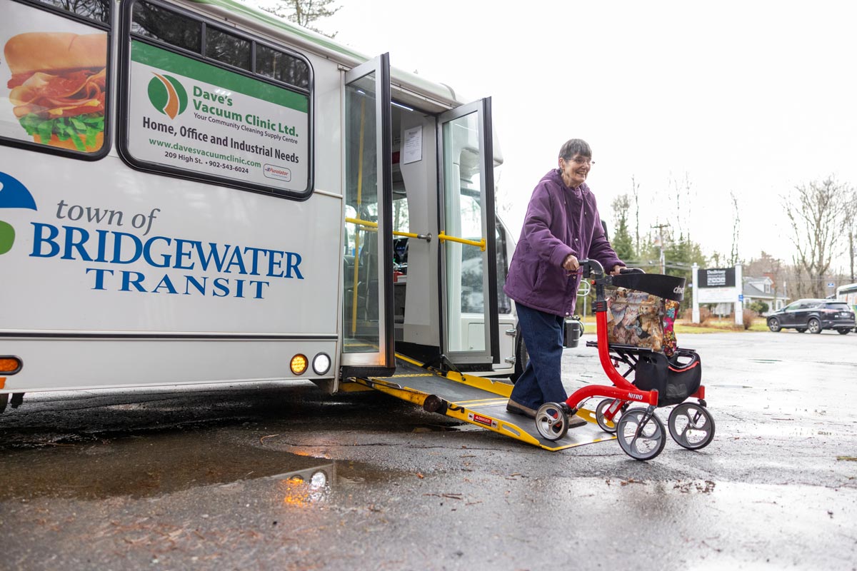 A person with a walker boarding a bus with a 'Bridgewater Transit' sign.